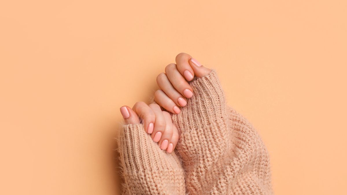 Hands with beautiful manicure on color background