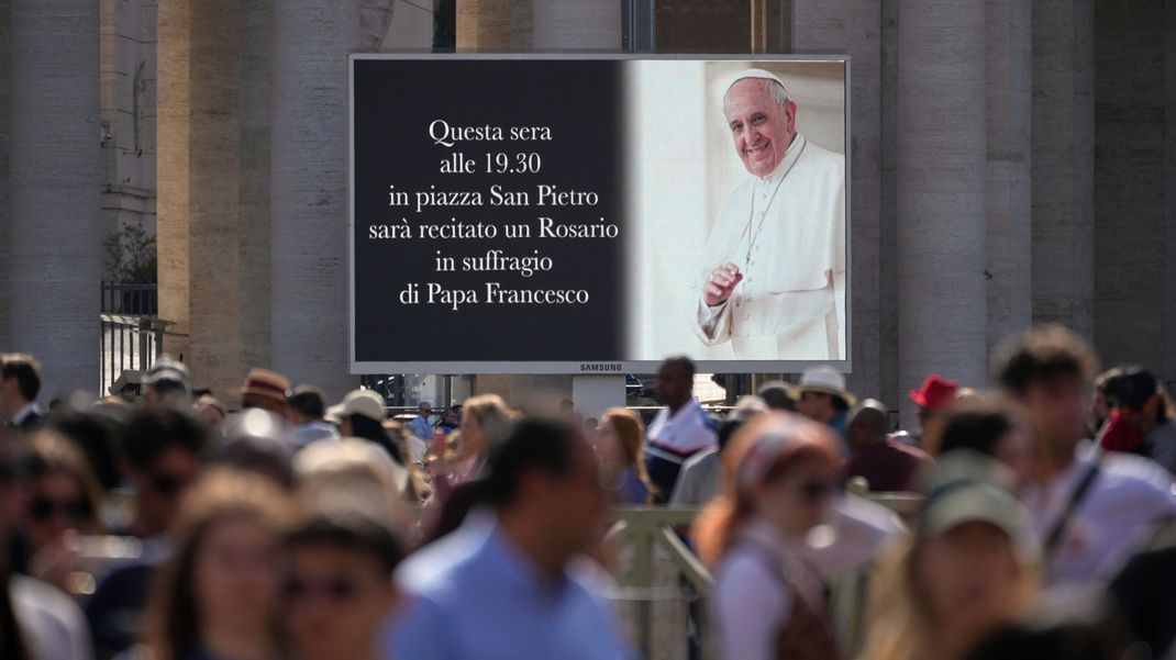 21. April 2025, Vatikan, Vatikanstadt: Auf einem riesigen Bildschirm auf dem Petersplatz wird angezeigt, dass um 19:30 Uhr ein Rosenkranzgebet für Papst Franziskus geplant ist. 